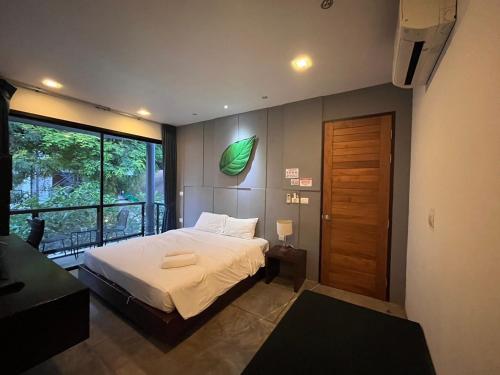 - une chambre avec un lit et une grande fenêtre dans l'établissement Z&Z Resort, à Rawai Beach