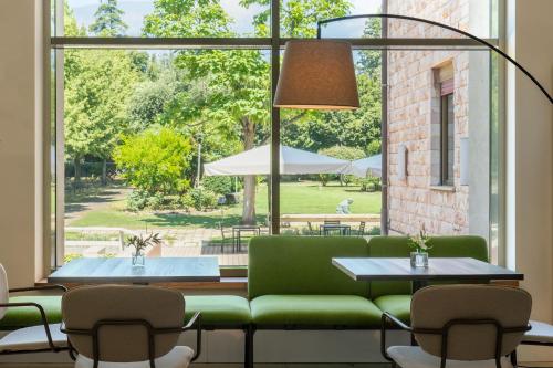 sala de estar con sofá verde y ventana grande en Domus Pacis Assisi en Assisi