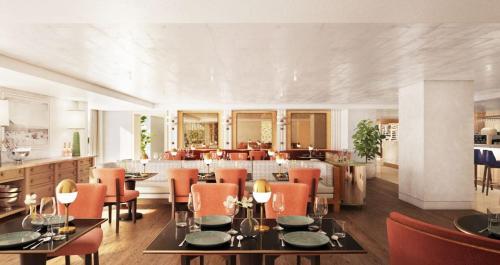 a dining room with tables and chairs and a kitchen at L'Ermitage Beverly Hills in Los Angeles