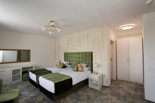 a bedroom with a large bed and a television at Sentir Hotel in Gura Humorului