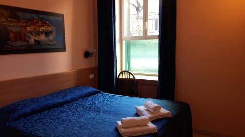 een slaapkamer met een bed met handdoeken erop bij Palma Residence in Rome