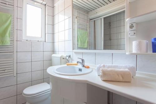 a white bathroom with a sink and a toilet at Skopje Panorama in Skopje