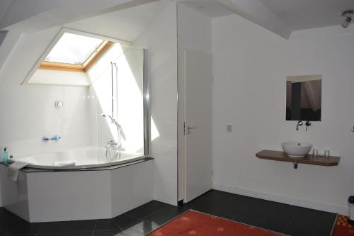 Hotel Oranjeoord في أبلدورن: حمام مع حوض استحمام ونافذة