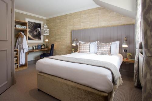 um quarto de hotel com uma cama grande e uma secretária em The Curious Pig in the Parlour em Burstow