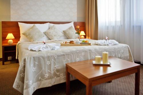 a hotel room with a bed with a tray of food on it at Hotel Janosik in Liptovský Mikuláš