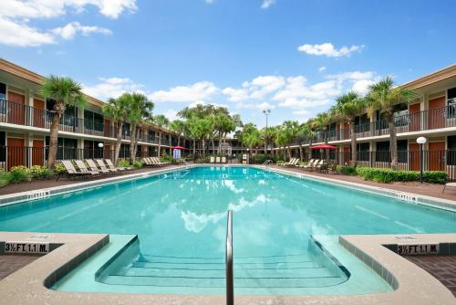 - une piscine dans la cour d'un immeuble dans l'établissement Ramada by Wyndham Kissimmee Gateway - Free Theme Park Shuttle, à Orlando