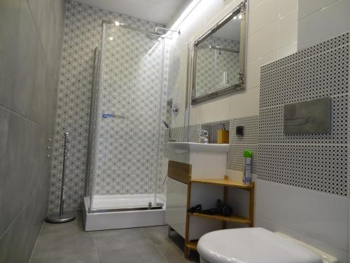 uma casa de banho com um chuveiro, um WC e um lavatório. em OperaApart em Varósvia