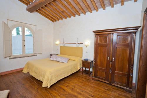 1 dormitorio con 1 cama, vestidor y ventana en La Locanda del Borgo en Pietralunga