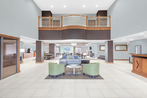 een lobby met een bank, stoelen en een tafel bij Wingate by Wyndham Sylvania-Toledo in Sylvania