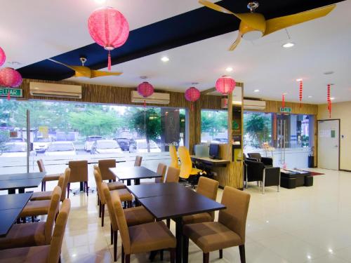 een restaurant met tafels en stoelen en roze lampen bij Eight Days Boutique Hotel - Mount Austin in Johor Bahru