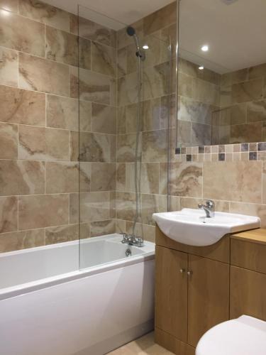 a bathroom with a tub and a sink and a toilet at Fir Tree Barn in Pollington