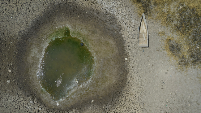 HUARINA, BOLIVIA – SEPTEMBER 29, 2023: An aerial view of a boat stuck in the dried lake bed of Lake Titicaca. The water level of Titicaca, the largest lake in South America, has been dropping drastically due to the unprecedented winter heat that hit the country. September 2023 was the warmest September on record for South America and the globe.