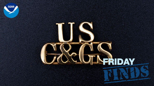 Photo of a gold pin with the letters "US" above "C&GS" in a serif font. The pin rests on a black background. The NOAA logo is in the upper left corner and the words "Friday Finds" are in the lower right corner.