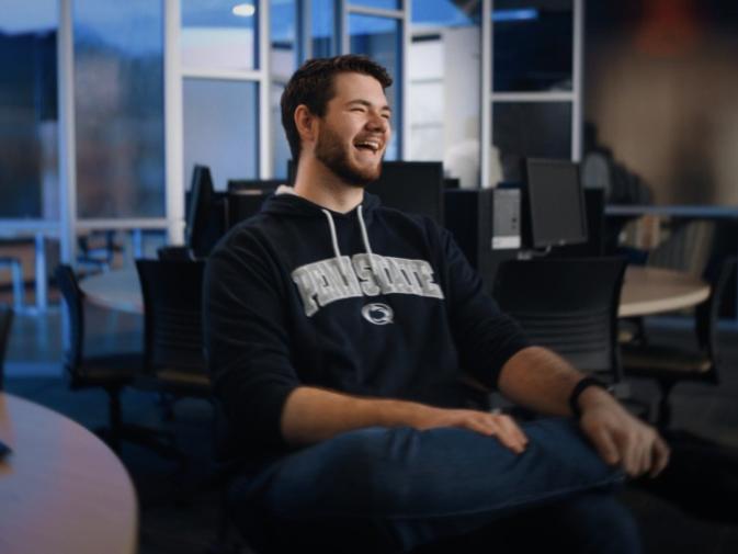 A student wearing a Penn State hat poses for a picture