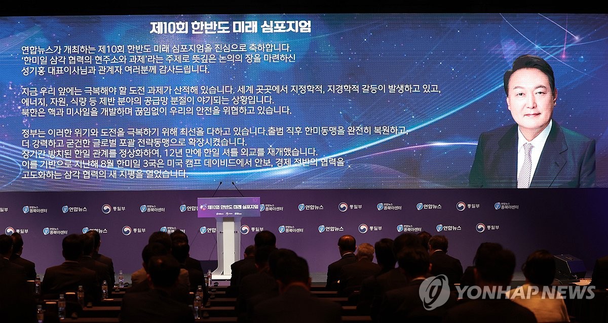 President Yoon Suk Yeol's message is shown on a screen at a symposium co-hosted by Yonhap News Agency and the unification ministry at the Shilla Hotel in Seoul on June 28, 2024. (Yonhap)