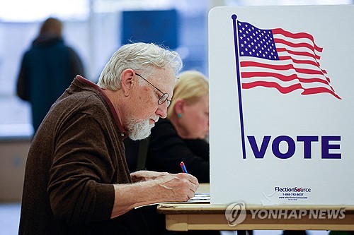 A man fills out his ballot during early voting for the U.S. general election at a polling station at Ottawa Hills High School in Grand Rapids, Michigan, on Nov. 3, 2024, in this photo released by AFP. (Yonhap)