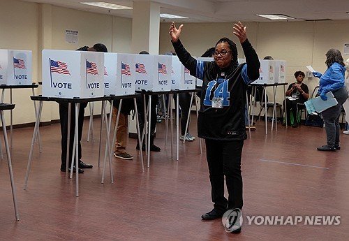 A poll worker motions to voters waiting to cast their votes during early voting in the U.S. presidential election at a polling station in Detroit, Michigan, on Nov. 3, 2024, in this photo released by Reuters. (Yonhap)