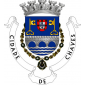 Escudo de azul, ponte de três arcos de prata, movente dos flancos, lavrada de negro, saínte de um contra-chefe ondado de prata e azul; em chefe, escudo de prata carregado de cinco escudetes de azul postos em cruz, carregado cada um de cinco besantes de prata e com uma bordadura de vermelho carregada de sete castelos de ouro, acompanhada de duas chaves de ouro, estando a da dextra volvida em cortesia. Escudo cercado pelo colar da Ordem militar de Torre e Espada do valor, lealdade e mérito. Coroa mural de prata de cinco torres.  Listel branco com  os dizeres : " CIDADE DE CHAVES ", a negro.