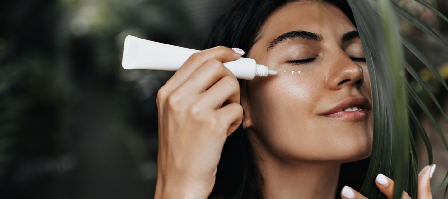 girl applying sunscreen on the eye area