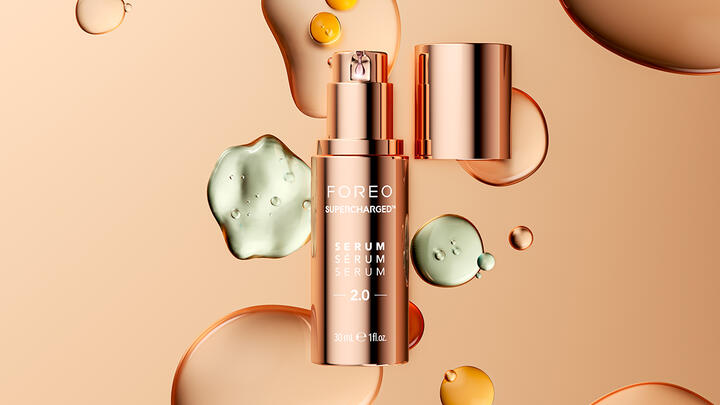 FOREO SUPERCHARGED Serum 2.0 in an abstract space surrounded with colorful drops of serum