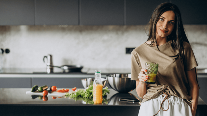 Woman in a kitchen, vegetables and fruit on a counter