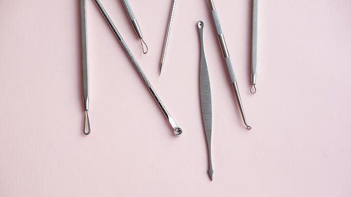 Tools for removing blackheads and acne on pink surface