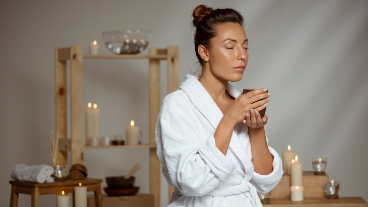 Woman in a white bathrobe enjoying a skincare routine