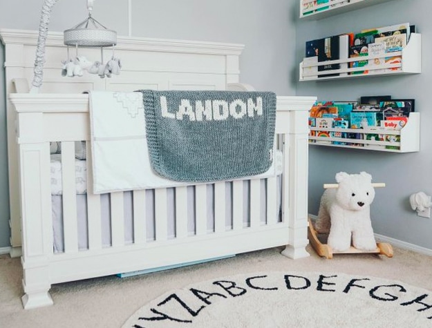 Crib with toys and wall shelves full of books