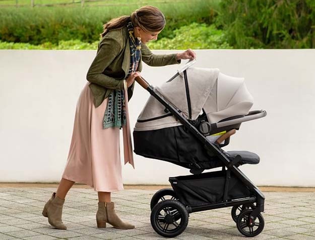 A woman pushing a Nuna Tavo Next Pipa RX travel system