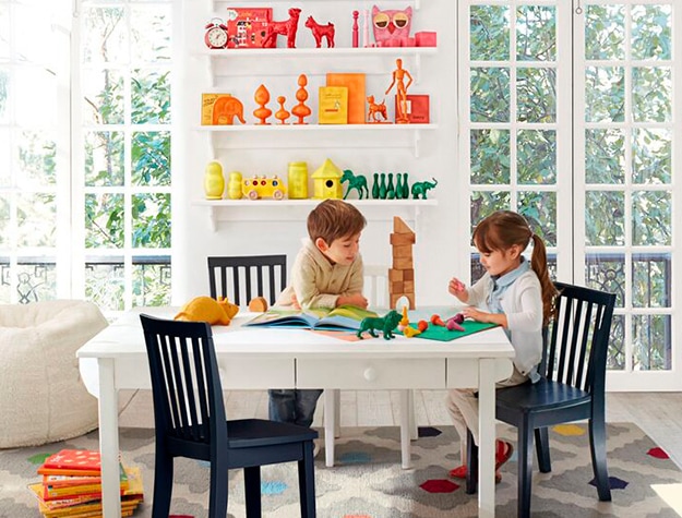 Organized rainbow shelf behind children playing