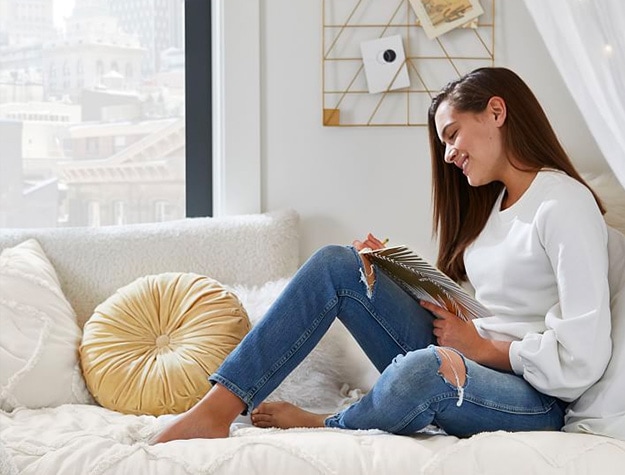 woman journaling on white sofa