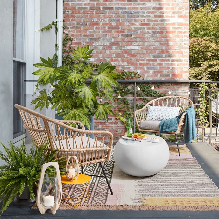 Rattan patio chairs, rug and small table.