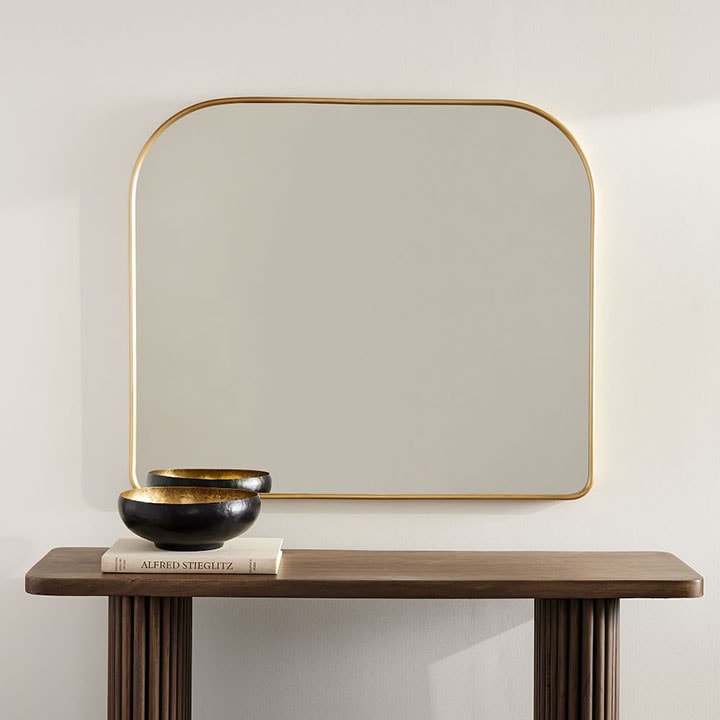 Metal streamline wide arch mirror over desk.