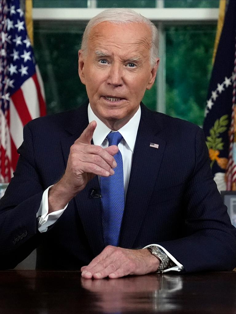 US-Präsident Joe Biden sitzt im dunklen Anzug an seinem Schreibtisch im Oval Office und gestikuliert mit seiner rechten Hand. Im Hintergrund sind Flaggen, Vorhänge und persönliche Fotos zu sehen