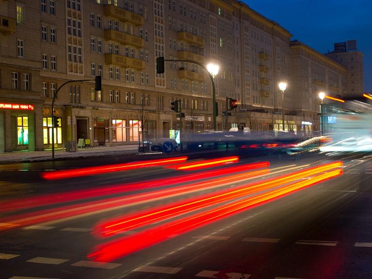 Die Rücklichter eines fahrenden Autos auf der Karl-Marx-Allee in Berlin.