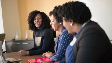 a team smiling at a desk together