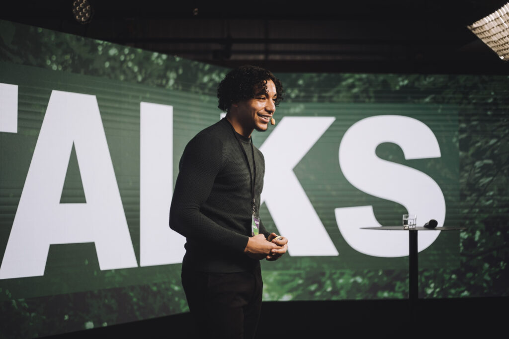 A man presenting on stage using the storytelling style presentation technique.