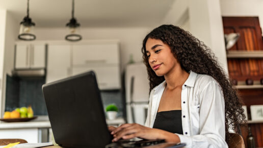 Young woman studying using laptop at home