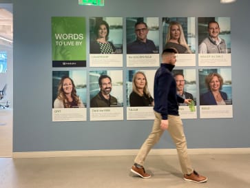 Employee walks by inspirational Words to Live by wall