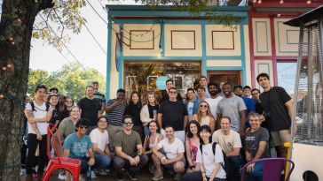 A group of January employees pose together outside a storefront. 