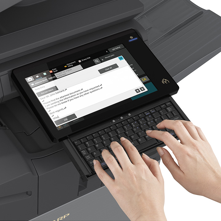 Person typing on retractable keyboard on Sharp Copier