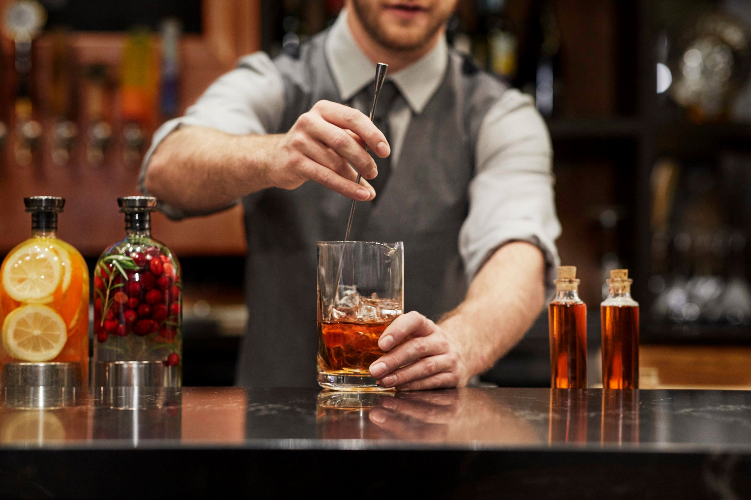 A bartender preparing a drink at the bar.