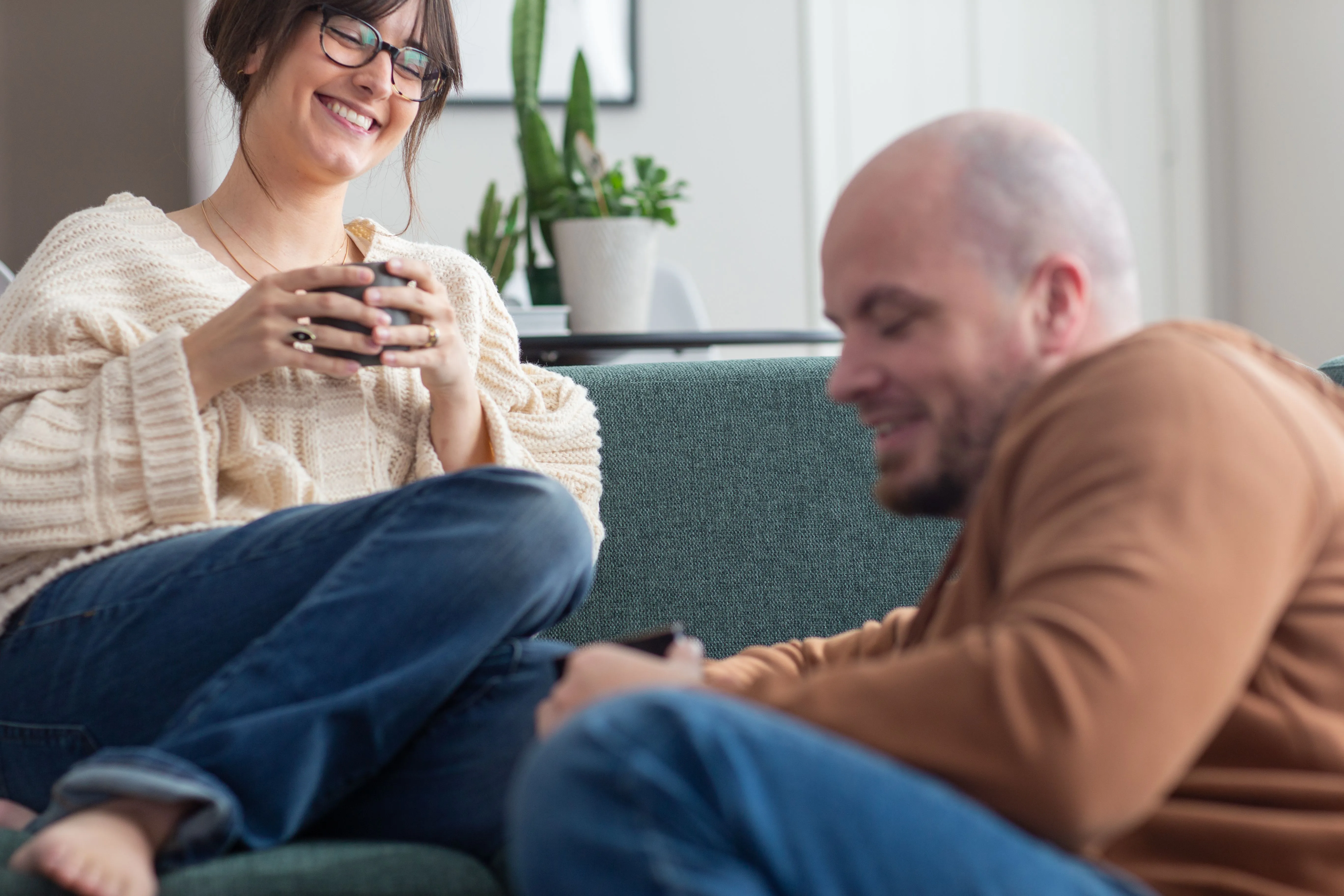 A couple smiling having coffee together.