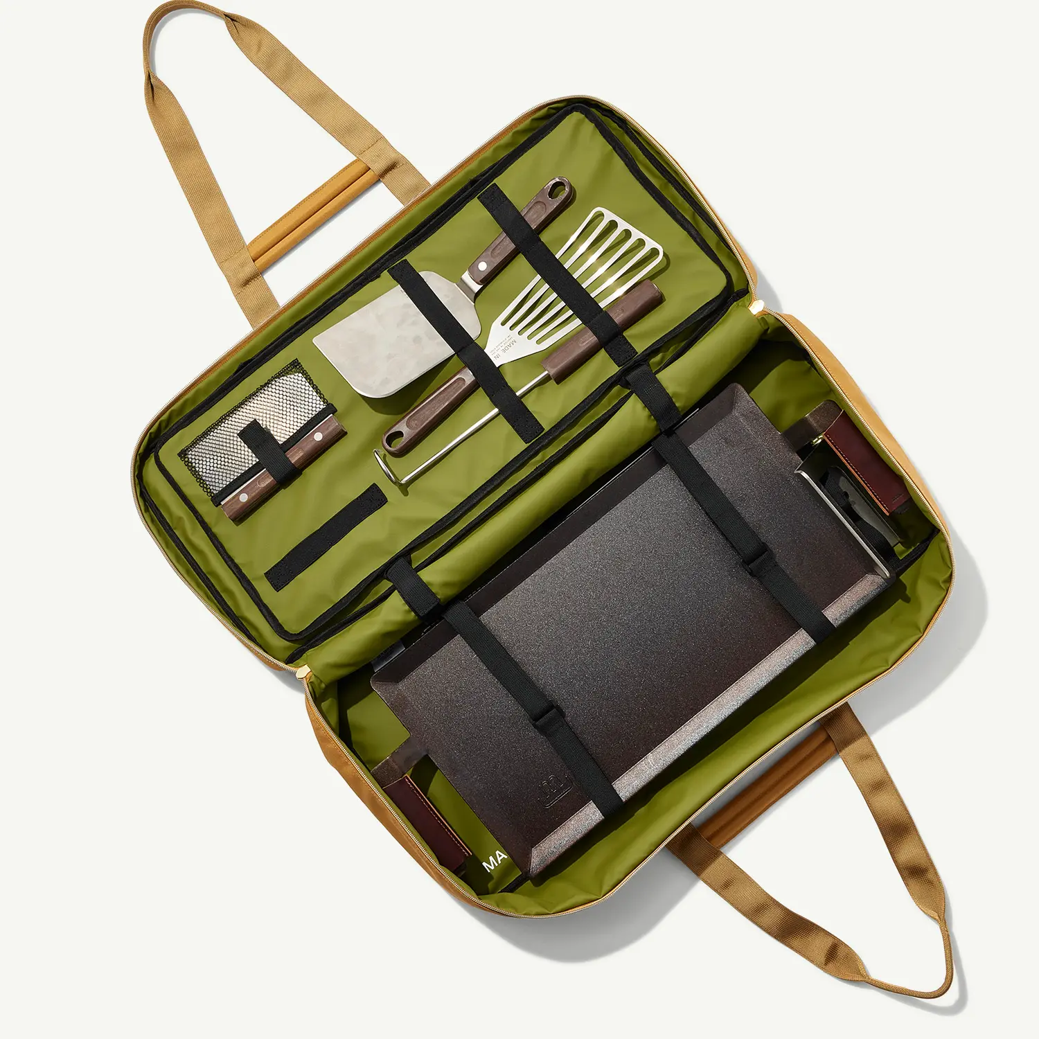 A portable barbecue set is neatly packed in a green carry case with utensils and grilling accessories.