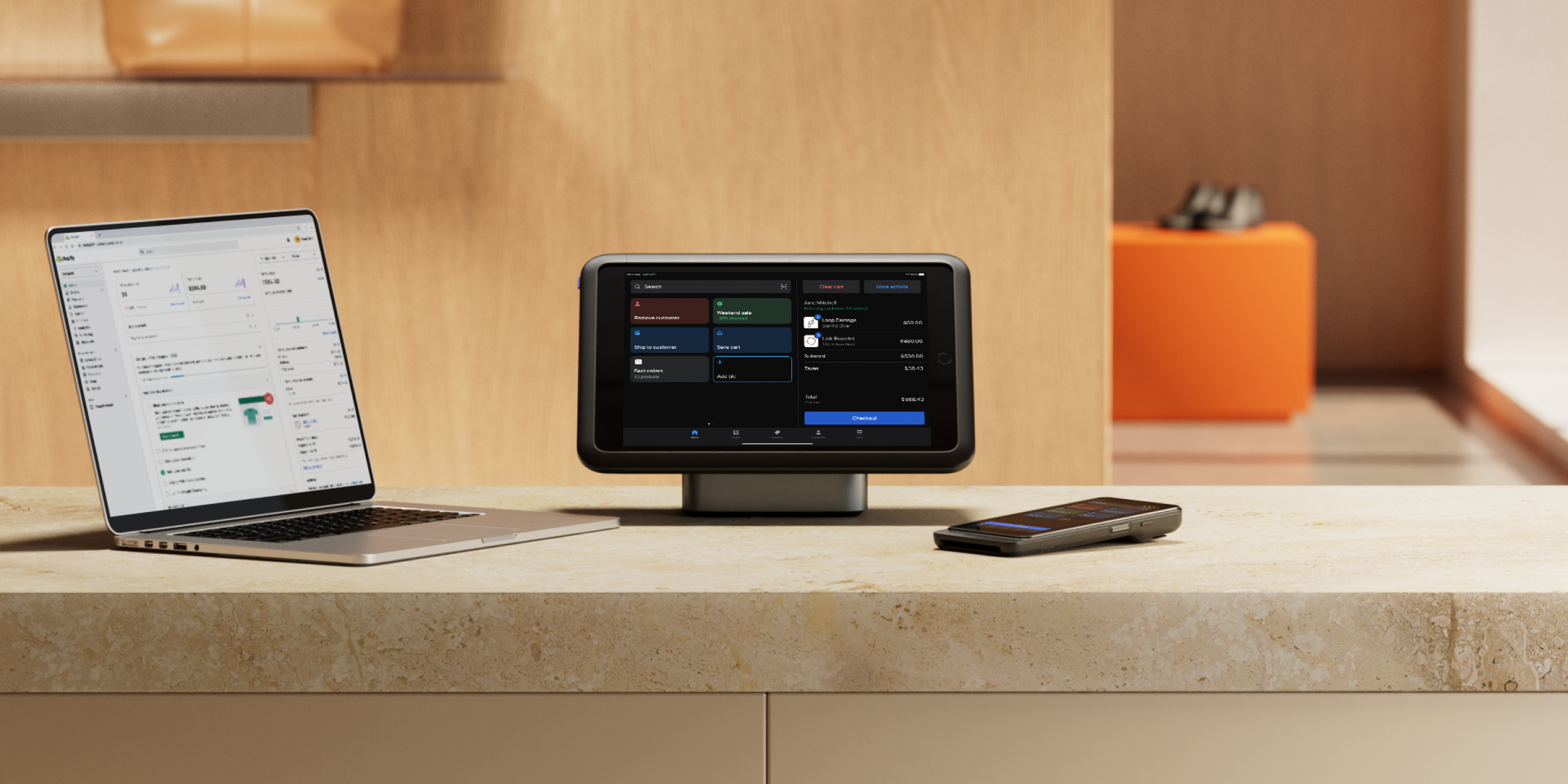 All the elements of Shopify POS sit on a retail counter: a laptop running the Shopify admin, a tablet mounted on a table stand running Shopify POS, the POS Go ready to take tap, swipe, and chip payments.