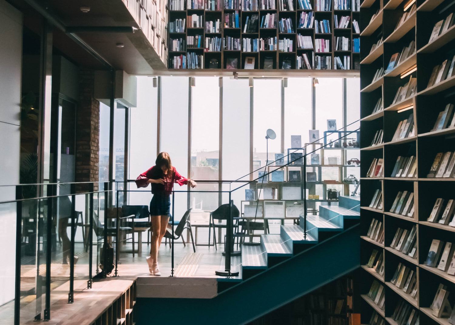 Person looks over the railing in a large multi-story bookstore