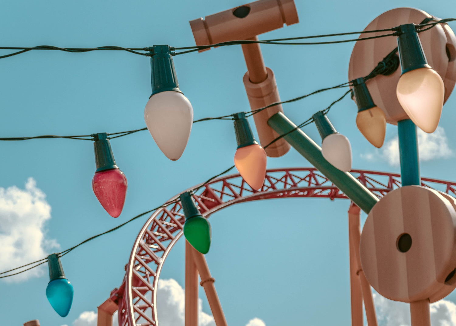 A string of lights hangs above a carnival