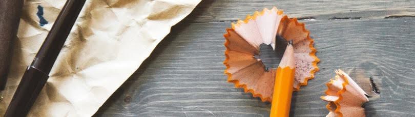 Paper and pencil for writing on a table with pencil shavings.