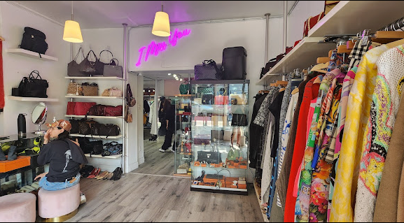 Photo of a vintage clothing store with racks of clothing on the right-hand side. Google