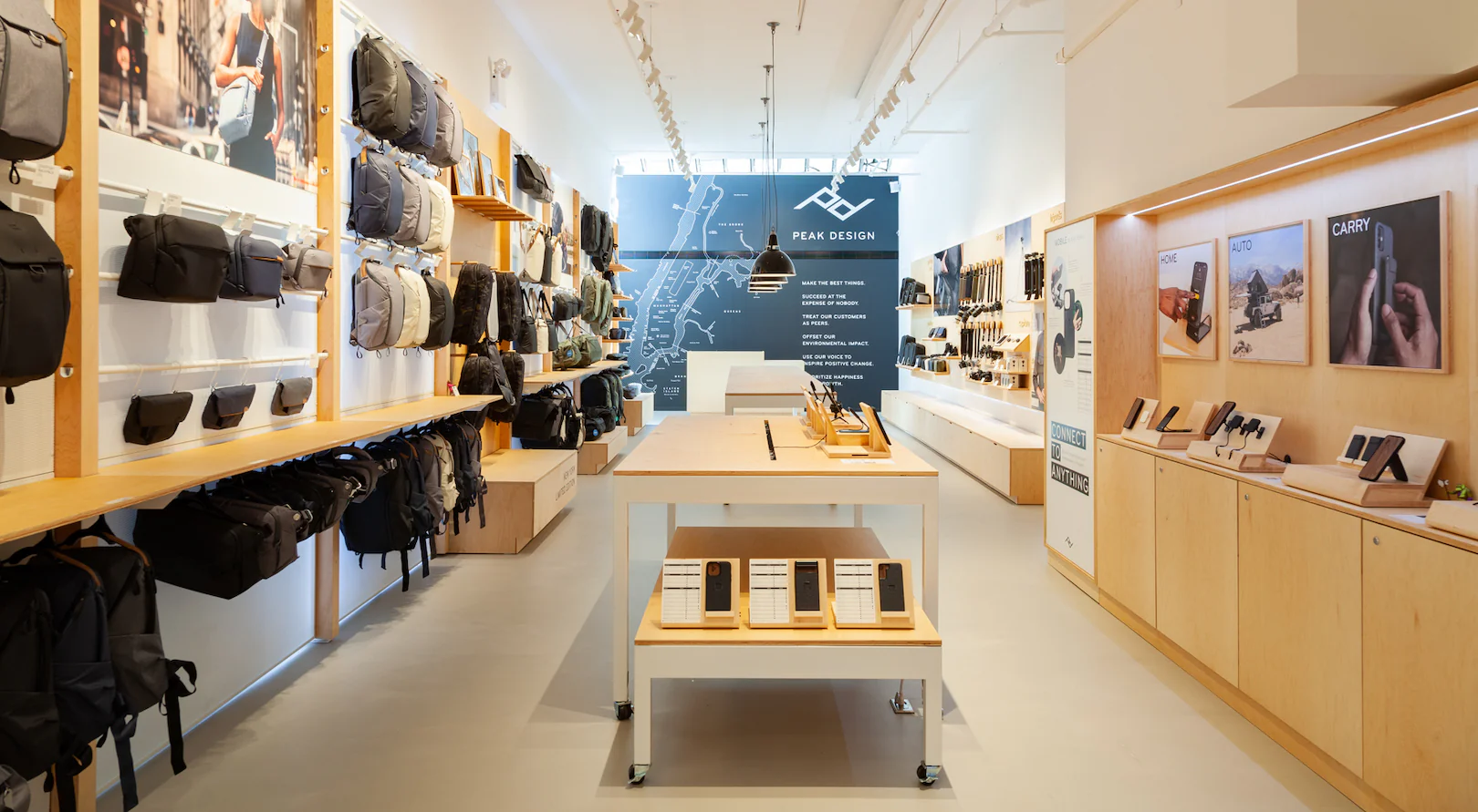 Store that sells backpacks and phone accessories with a blue focal wall against wood furnishings.